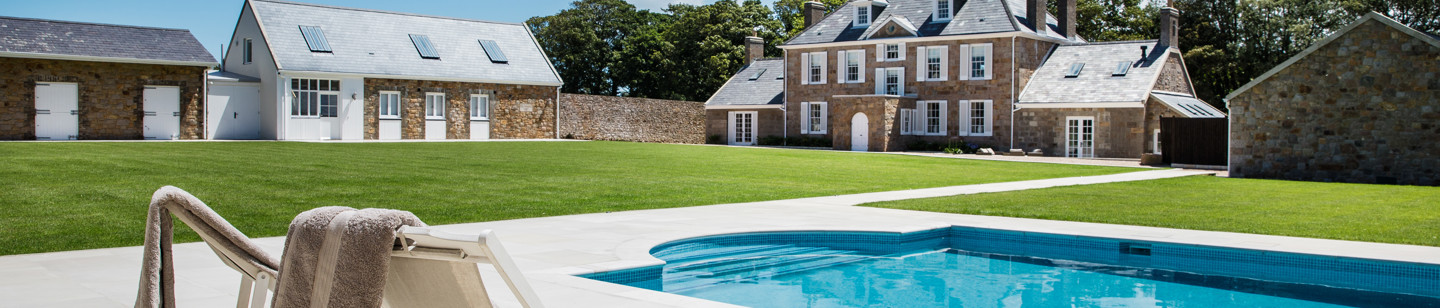 Jersey converted farmhouse with a swimming pool and deck chairs