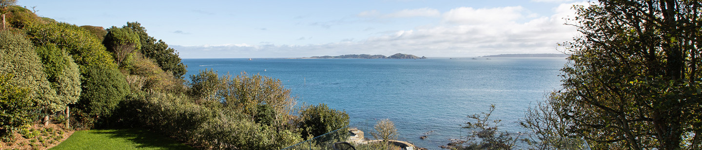 Garden in Guernsey with a patio section and sea view