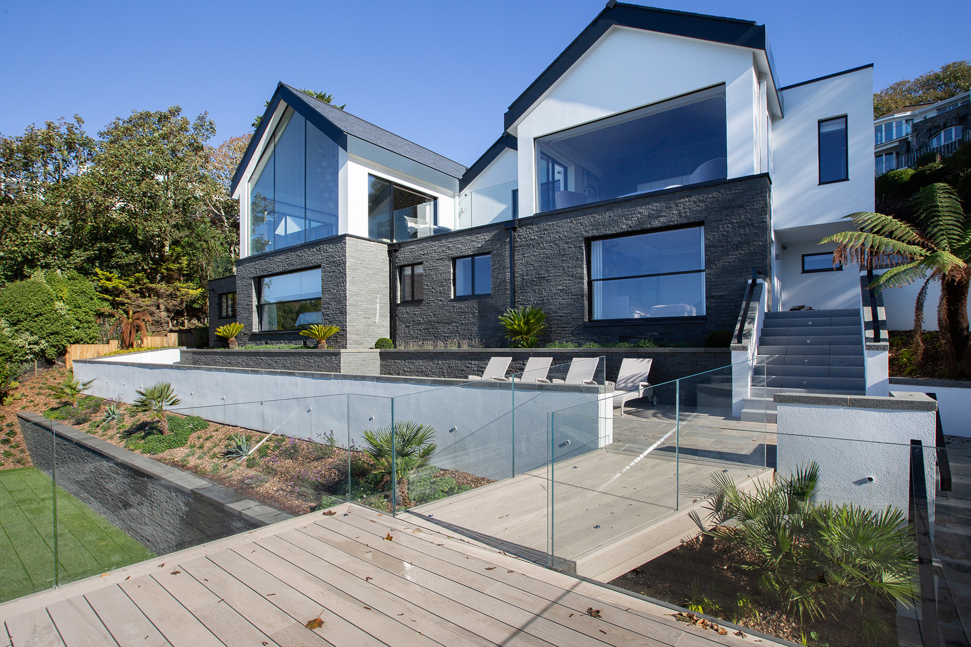 Modern house with decking, deck chairs, and large windows in Fort George